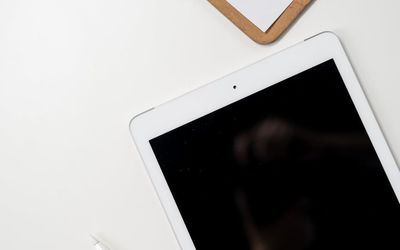 Color palette and digital stylus on dark desk