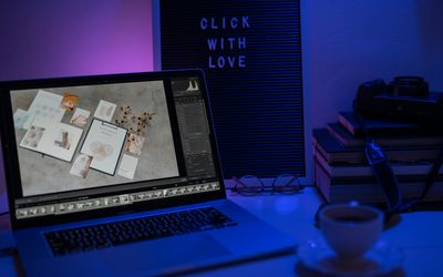 Stacks of books next to a glowing laptop